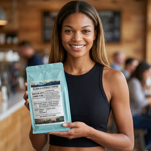 Woman holding a package of Selden & Kingley Coffee in a coffee shop setting
